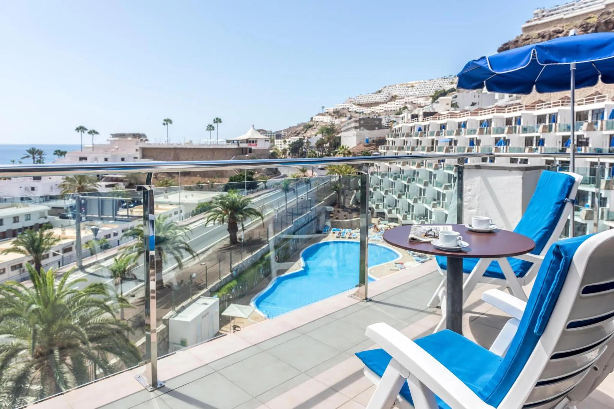 Terrasse avec mobilier d'extérieur et vue sur la mer et une piscine.
