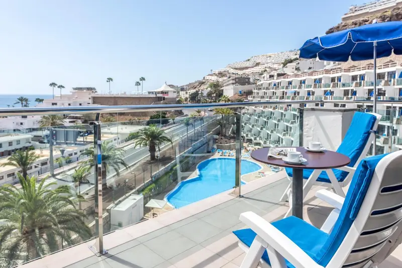 Terrasse avec mobilier d'extérieur et vue sur la mer et une piscine.