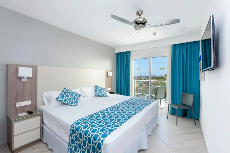 Une chambre lumineuse avec un grand lit et un accès à une terrasse.