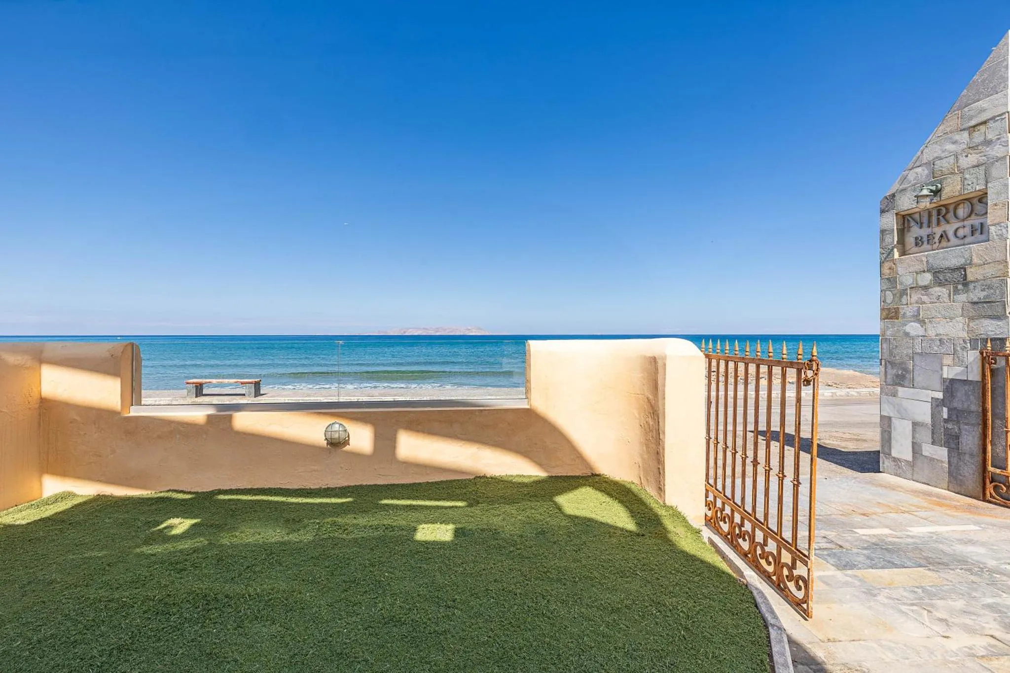 Terrasse avec gazon synthétique donnant sur la mer.