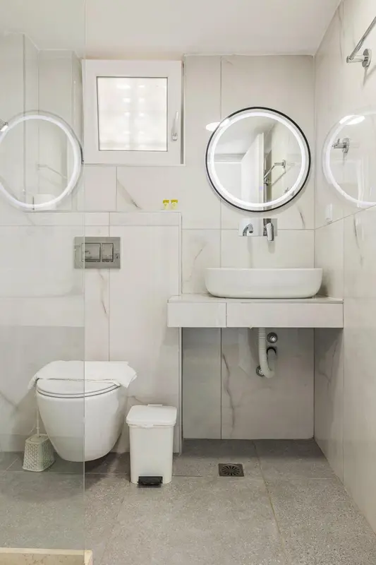 Une salle de bain moderne avec des carreaux blancs et un lavabo surélevé.