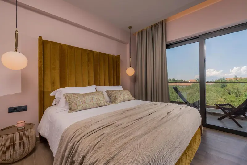 Une chambre lumineuse avec un grand lit et un accès à une terrasse.