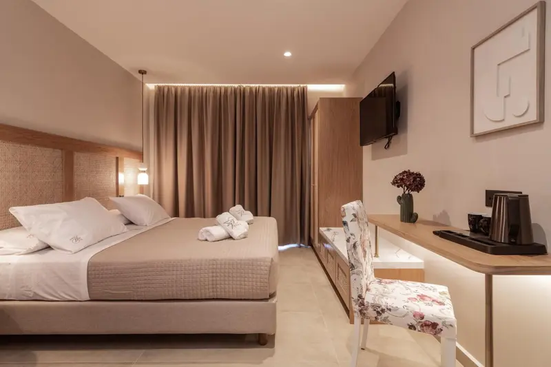 Une chambre lumineuse avec un grand lit et un coin bureau.