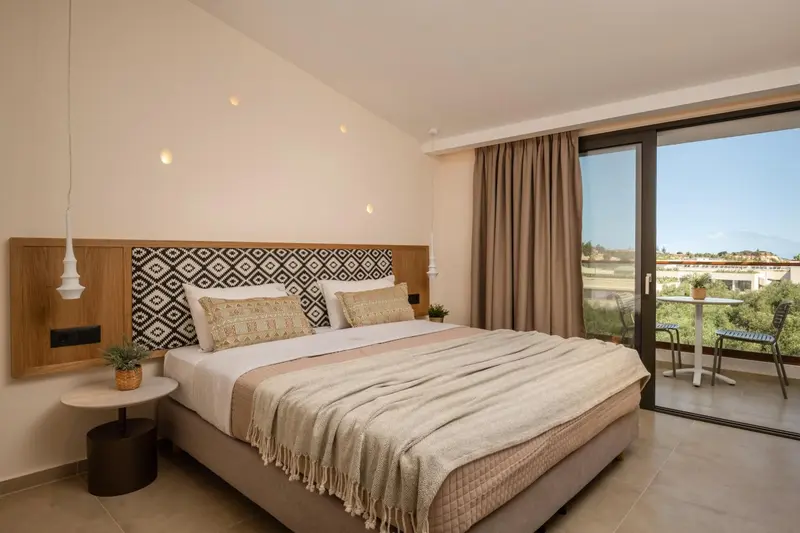 Une chambre lumineuse avec un grand lit et un accès à une terrasse.