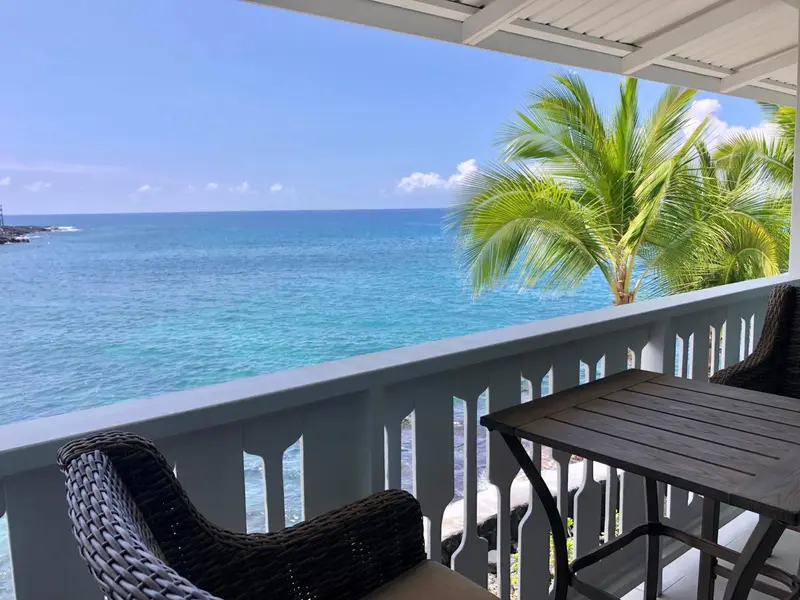 Vue sur la mer depuis une terrasse avec mobilier d'extérieur.