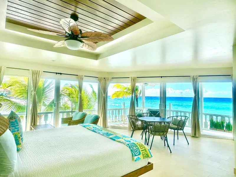 Une chambre lumineuse avec un grand lit et une vue sur la mer.