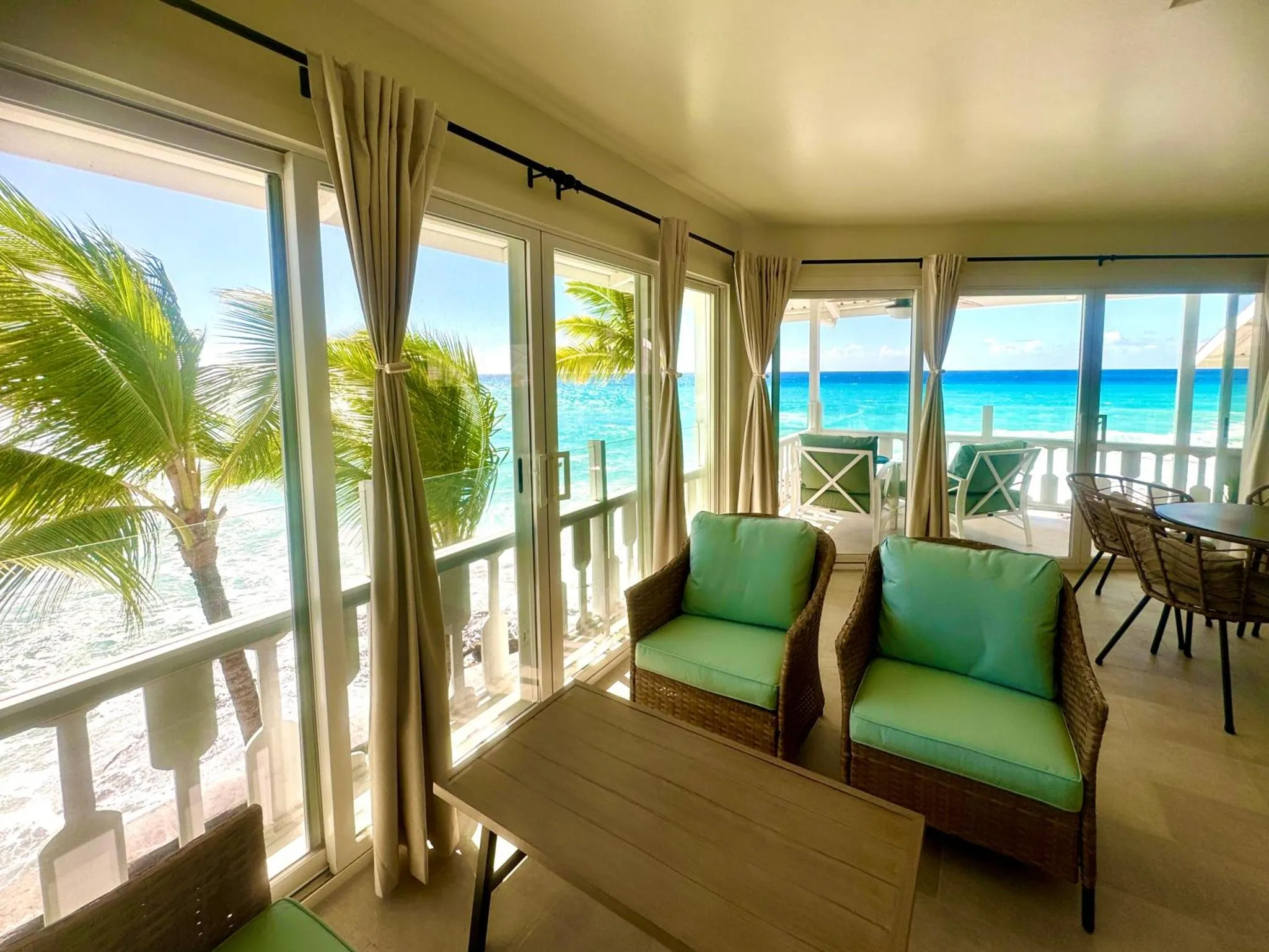 Espace de détente avec mobilier en rotin et vue sur la mer.