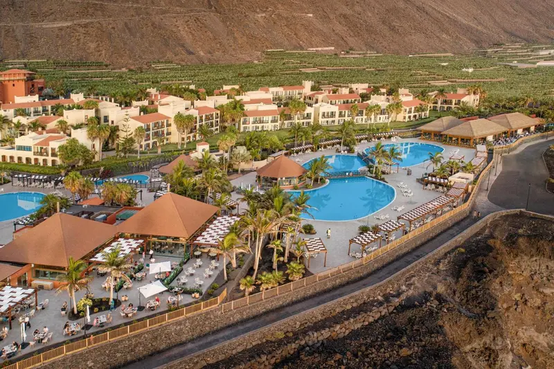Vue aérienne d'un complexe hôtelier avec piscines et végétation luxuriante.