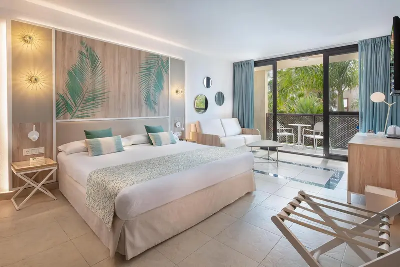 Une chambre lumineuse avec un grand lit et un accès à une terrasse.