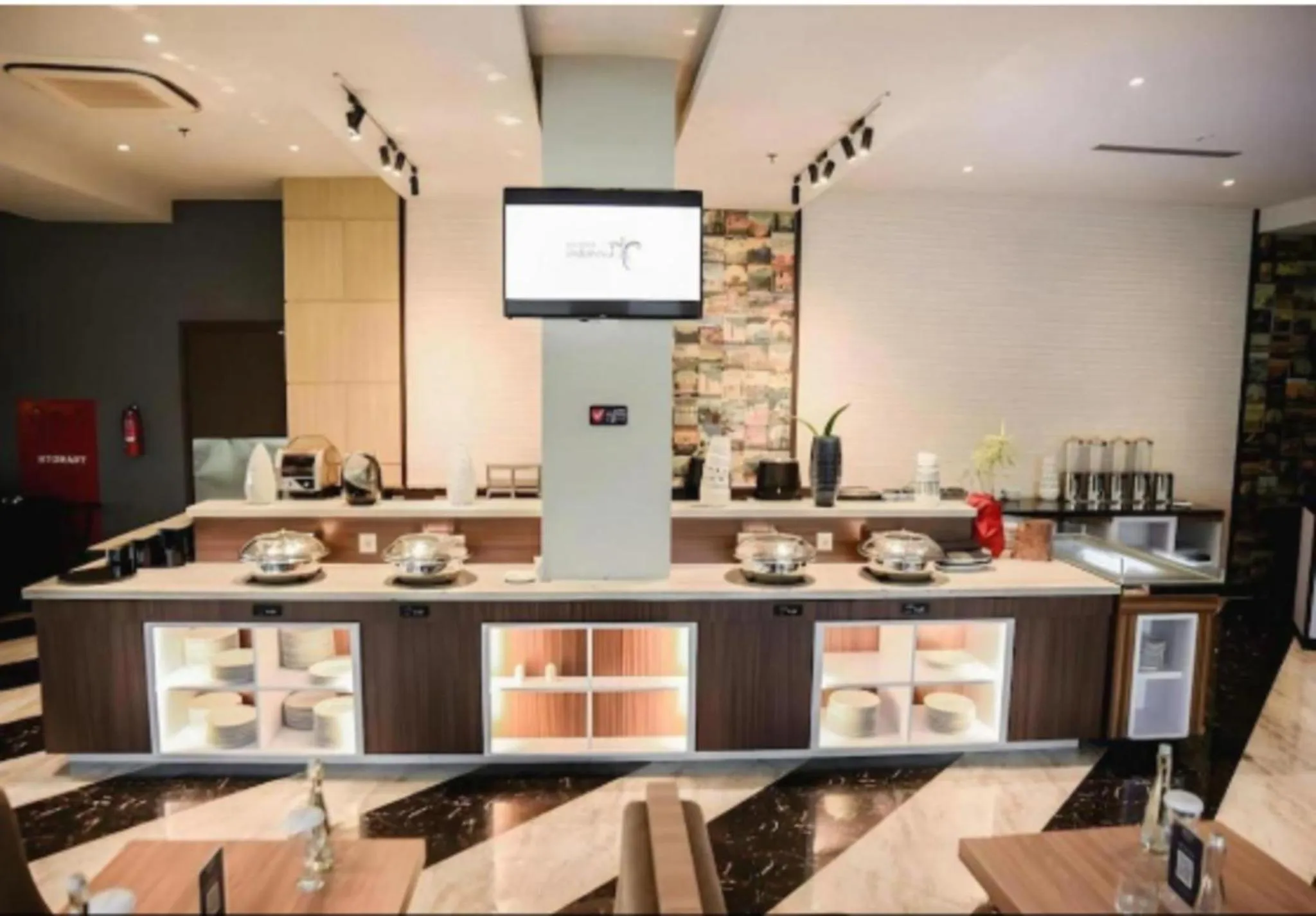 Un comptoir de buffet garni de plats et de boissons dans une salle lumineuse.