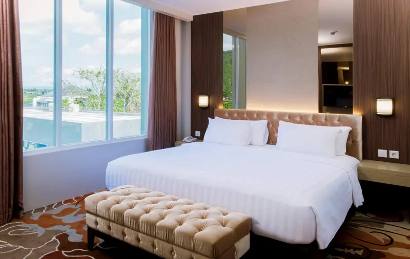 Une chambre d'hôtel lumineuse avec un grand lit et une vue sur l'extérieur.