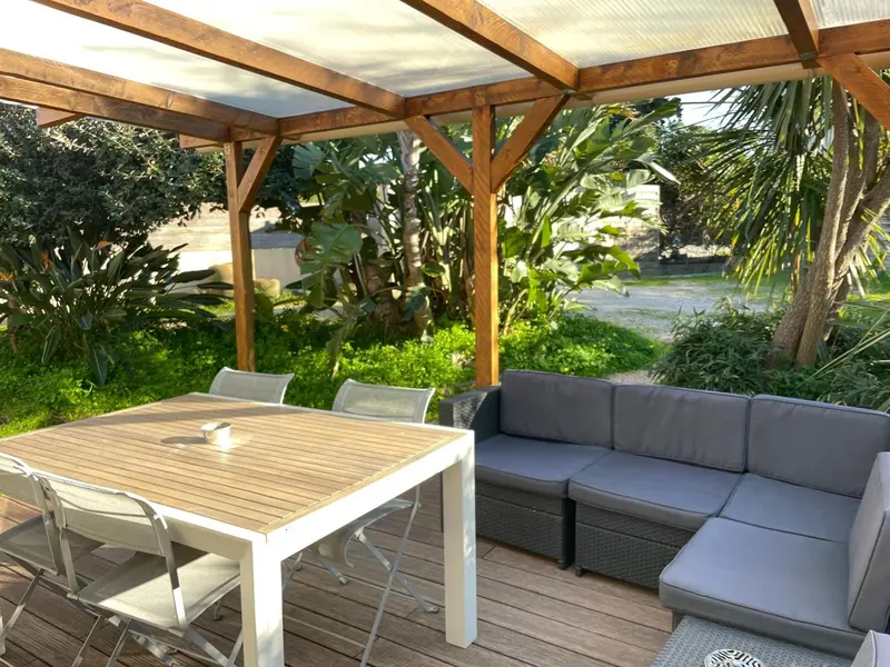Espace de détente extérieur avec table et canapé.