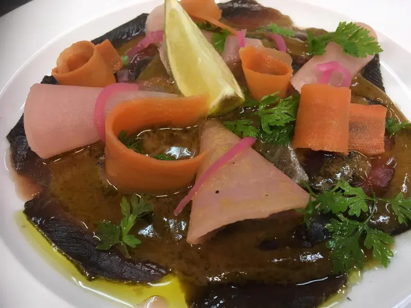Assiette de mets raffinés avec des légumes et une sauce.