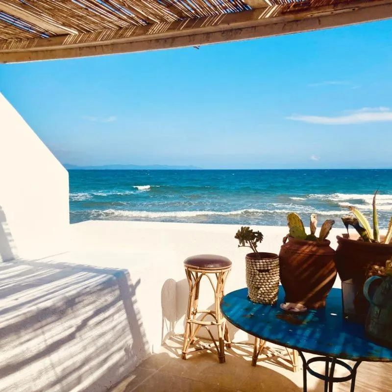 Terrasse ombragée donnant sur la mer et le ciel bleu.