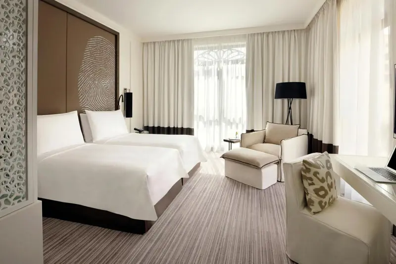 Une chambre lumineuse avec un grand lit et un coin salon.
