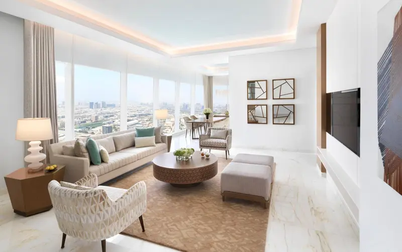 Un salon moderne avec canapé, fauteuils et table basse offre une vue sur la ville.