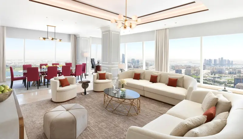 Un salon lumineux s'ouvre sur une salle à manger avec vue sur la ville.