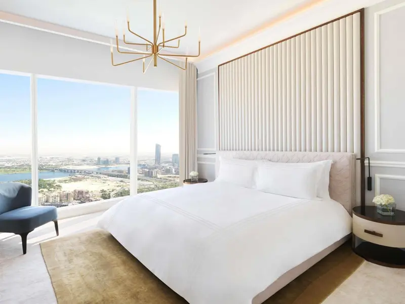 Une chambre lumineuse avec un grand lit et une vue sur la ville.