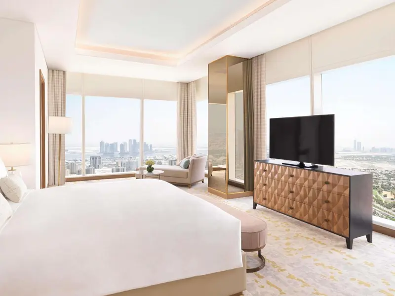 Une chambre lumineuse avec un grand lit et une vue sur la ville.