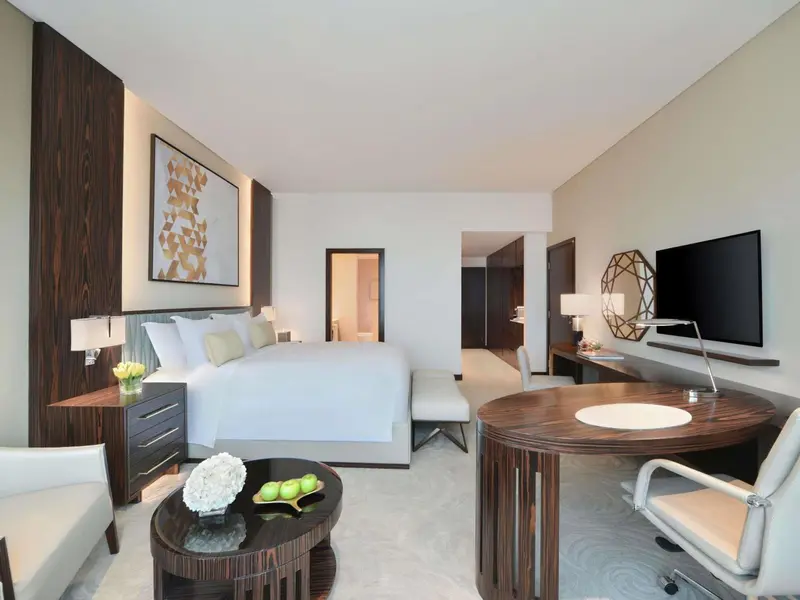 Une chambre lumineuse avec un grand lit et un espace bureau.