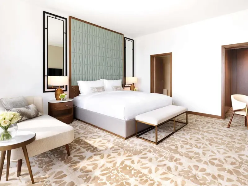 Une chambre lumineuse avec un grand lit et un espace détente.