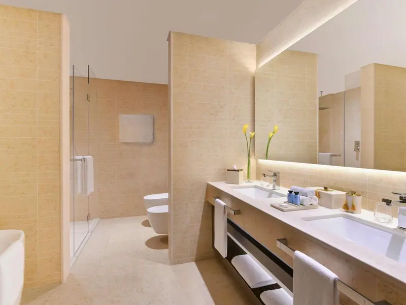 Une salle de bain lumineuse avec douche à l'italienne et vasque double.