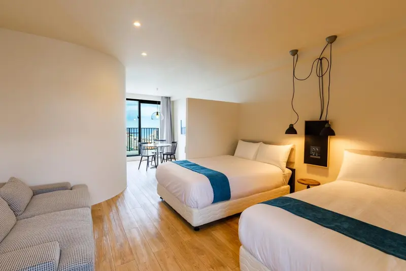 Une chambre lumineuse avec un lit double et un espace salon.