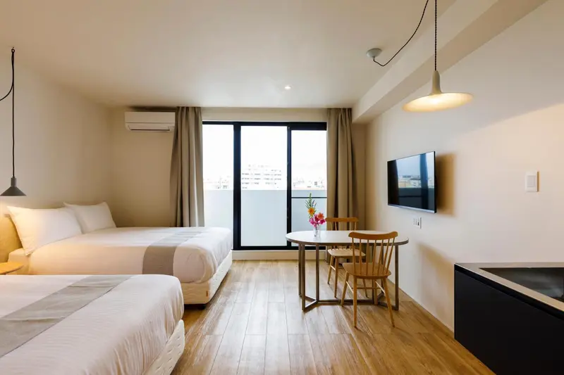 Une chambre lumineuse avec un lit double et un coin repas.