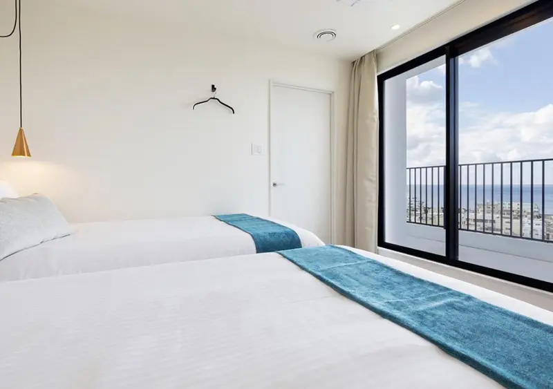 Une chambre lumineuse avec un lit et une vue sur la mer.