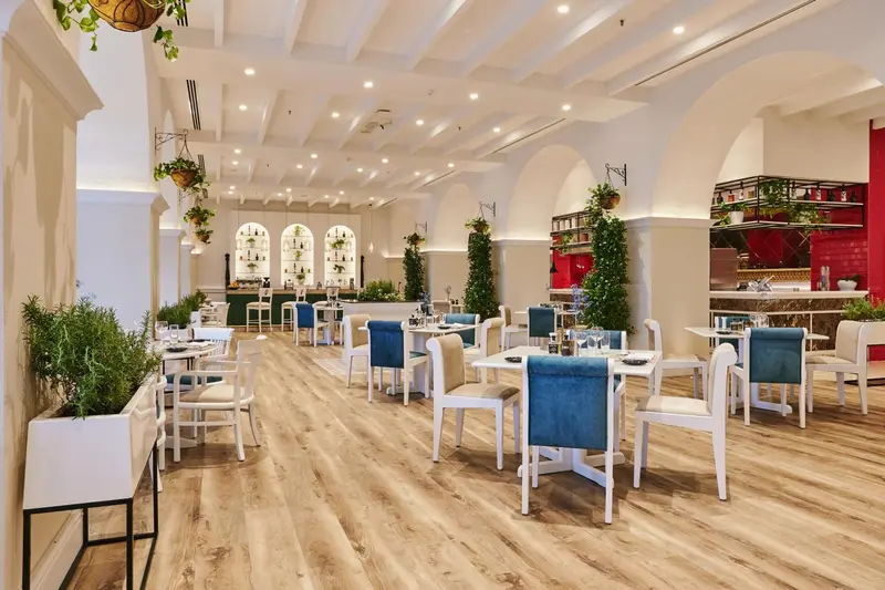 Une salle lumineuse avec des tables et des chaises pour les repas.
