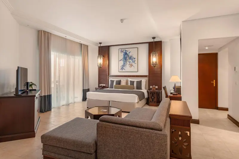 Une chambre spacieuse avec un grand lit et un coin salon.