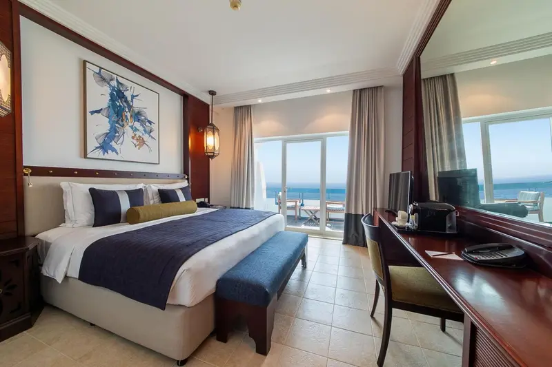 Une chambre lumineuse avec un grand lit et une vue sur la mer.