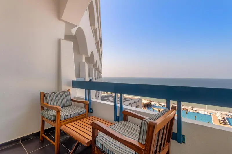Terrasse avec mobilier en bois donnant sur la mer.