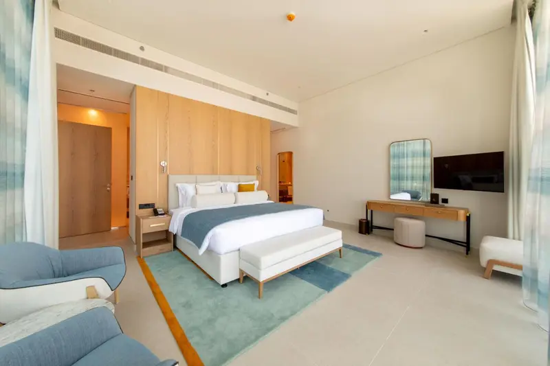 Une chambre lumineuse avec un grand lit et un espace détente.