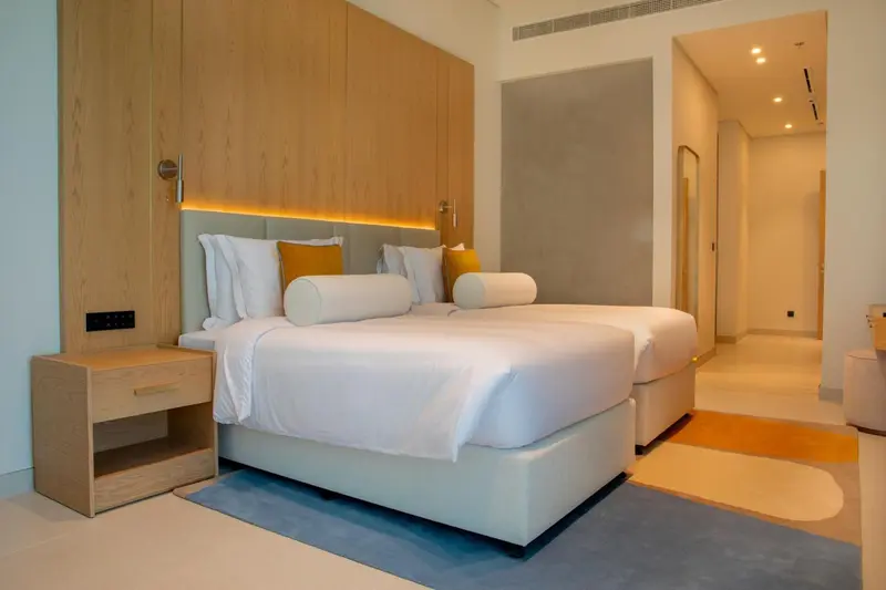 Une chambre lumineuse avec deux lits simples et une décoration moderne.