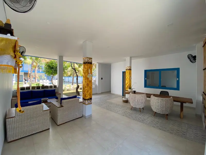 Espace de détente intérieur avec canapés et mobilier en rotin.