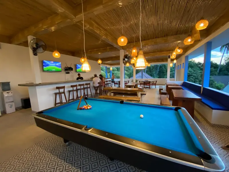 Une salle de détente avec un bar et un billard offre un espace convivial et lumineux.