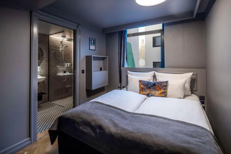 Une chambre moderne avec un lit et une salle de bain attenante.