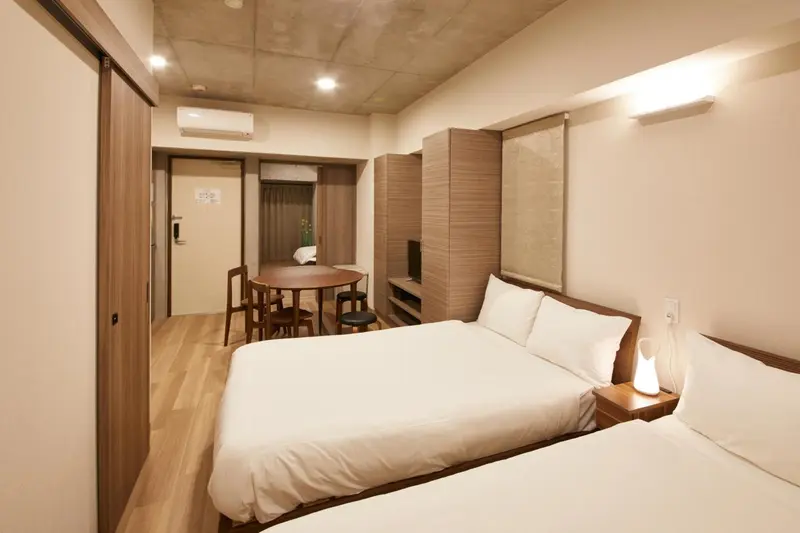 Une chambre lumineuse avec un lit double et une table à manger.