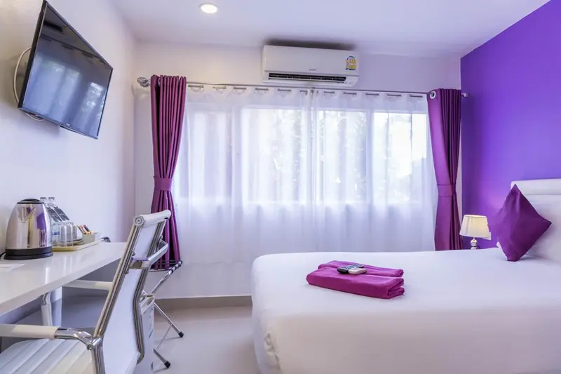 Une chambre lumineuse avec un lit et un espace bureau.