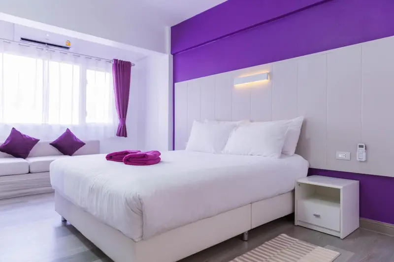 Une chambre lumineuse avec un grand lit et un canapé.