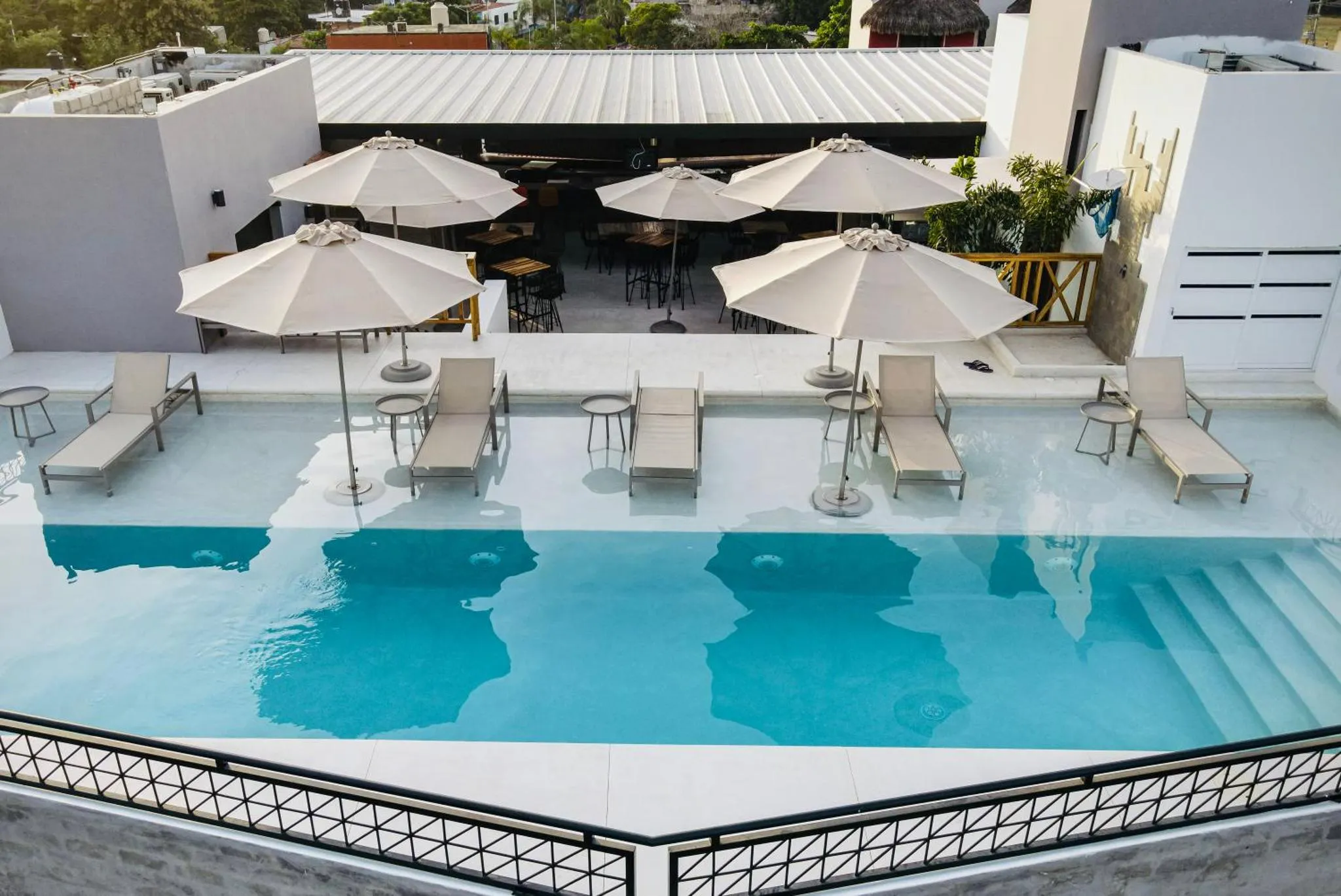 Terrasse avec piscine et mobilier de détente.
