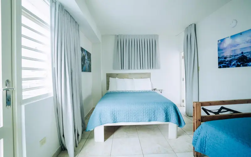 Une chambre lumineuse avec un lit double et une décoration sobre.