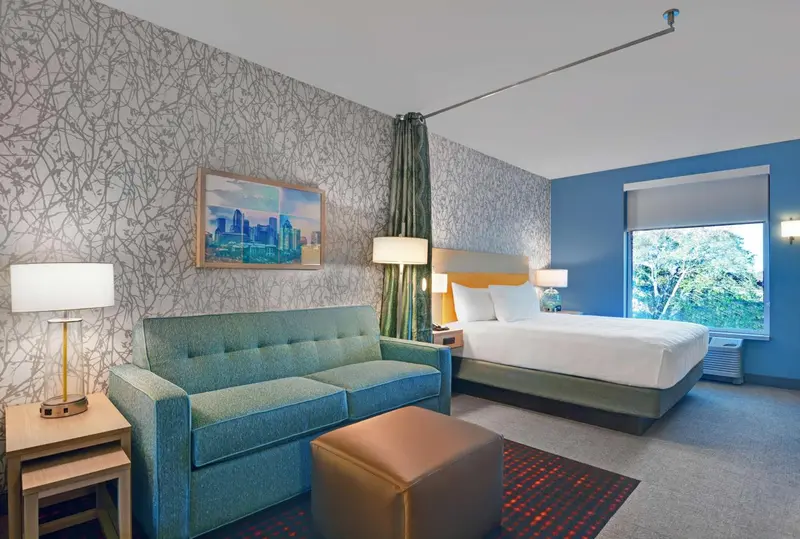 Une chambre lumineuse avec un canapé et un grand lit.