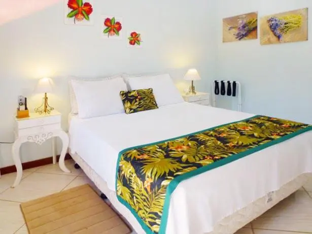 Une chambre lumineuse avec un grand lit recouvert d'une courtepointe colorée.