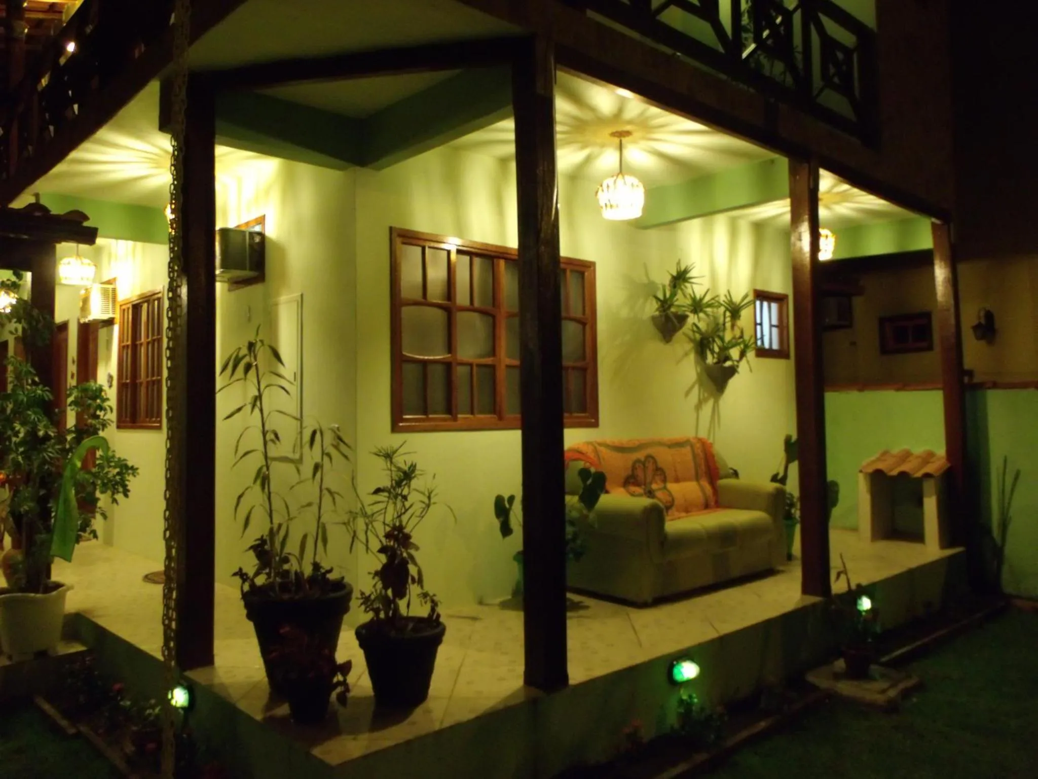 Espace de détente lumineux avec canapés et plantes vertes.