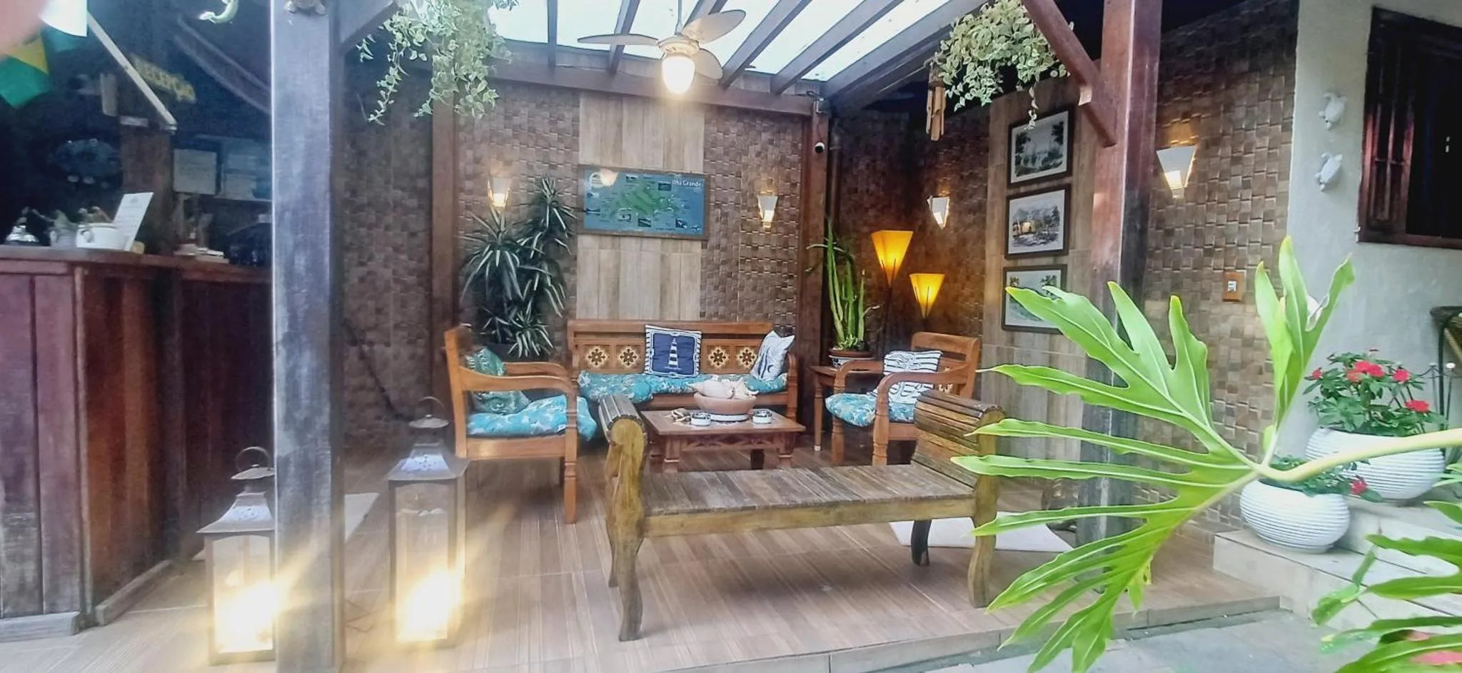 Espace de détente extérieur avec mobilier en bois et plantes tropicales.