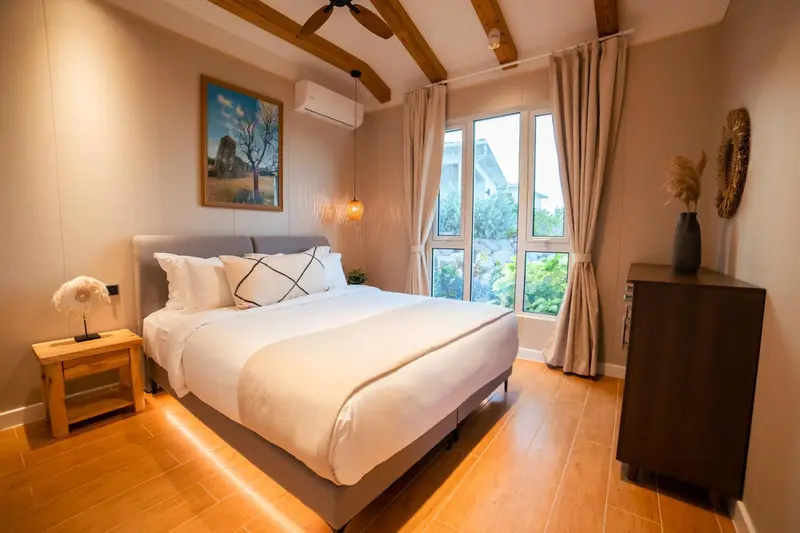 Une chambre lumineuse avec un grand lit et un décor sobre.