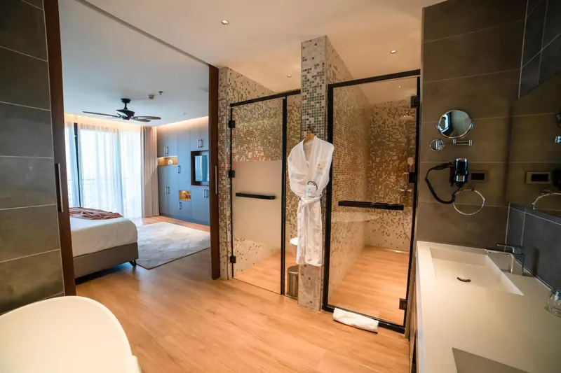 Une chambre spacieuse avec salle de bain attenante et vue sur la mer.