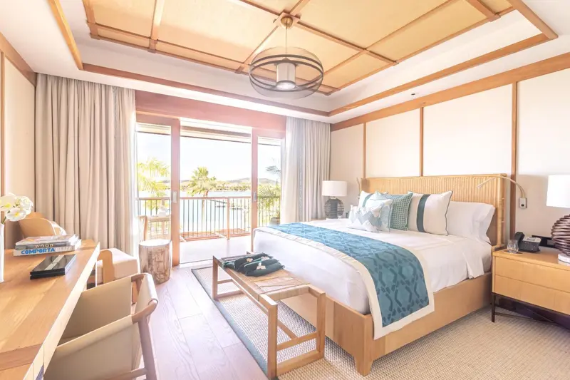 Chambre lumineuse avec un grand lit et vue sur la mer.